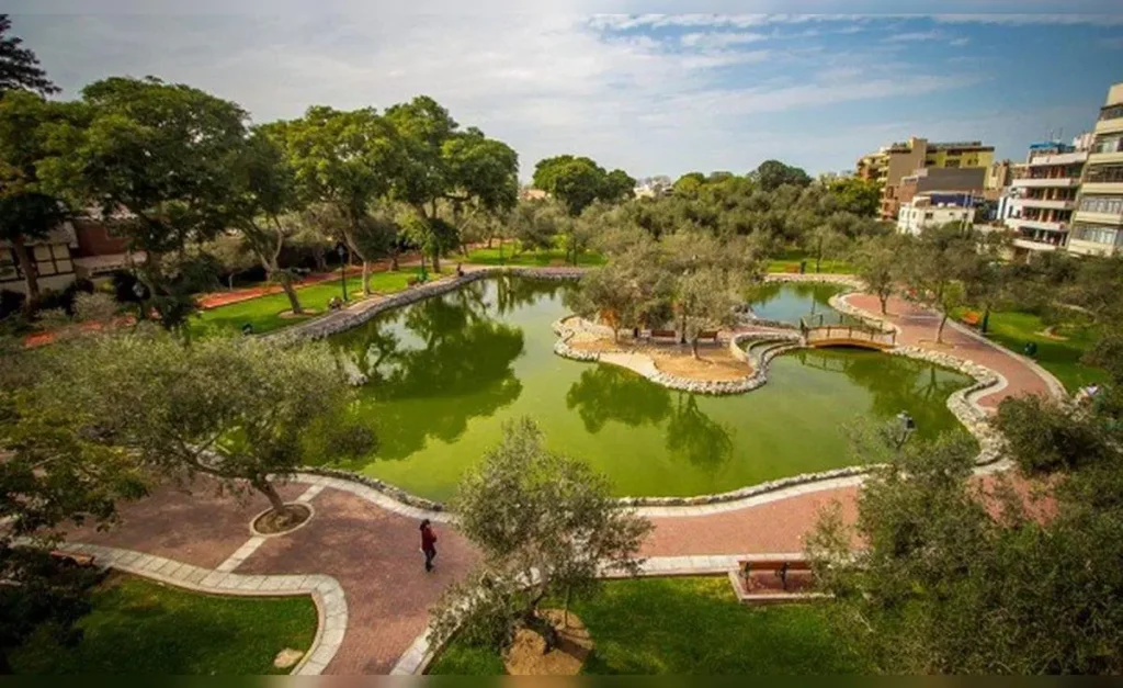 parque con una laguna y bastantes árboles alrededor